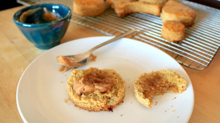 Oat biscuit served with a dollop of butter on top.