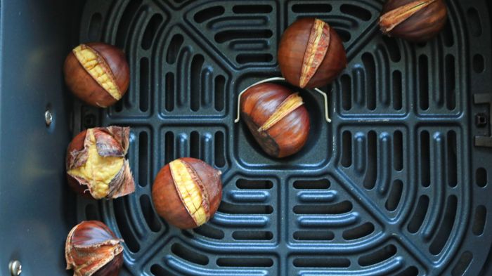 Chestnuts roasted in an air fryer basket.