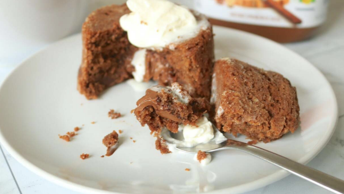 A chocolate lava cake cracked open on a plate.