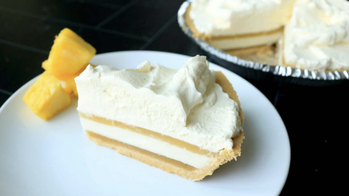 A tropical coconut and pineapple pie accompanied by pineapple chunks.