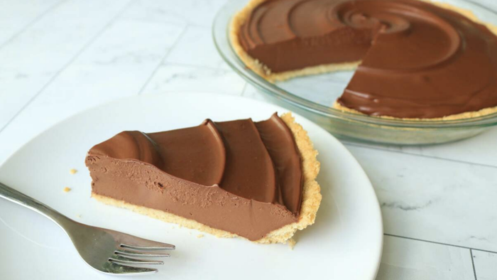 A slice of chocolate pudding pie served on a white plate.