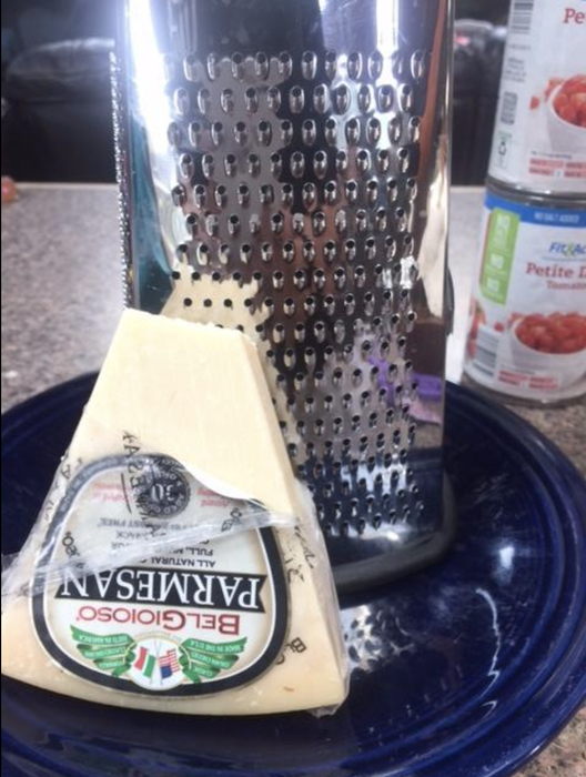 A reviewer's block of cheese waiting to be grated with the box grater.