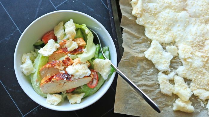 A salad sits beside a tray of crunchy, savory meringues.