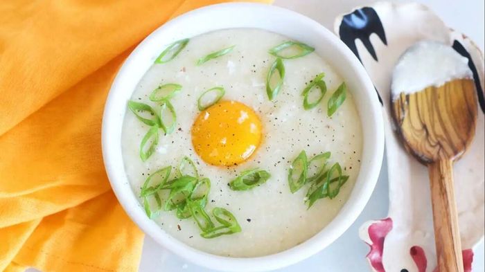 a raw egg mixed into a bowl of grits