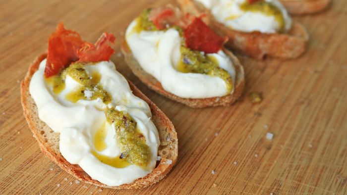 Whipped ricotta drizzled with pesto on toasted bread.