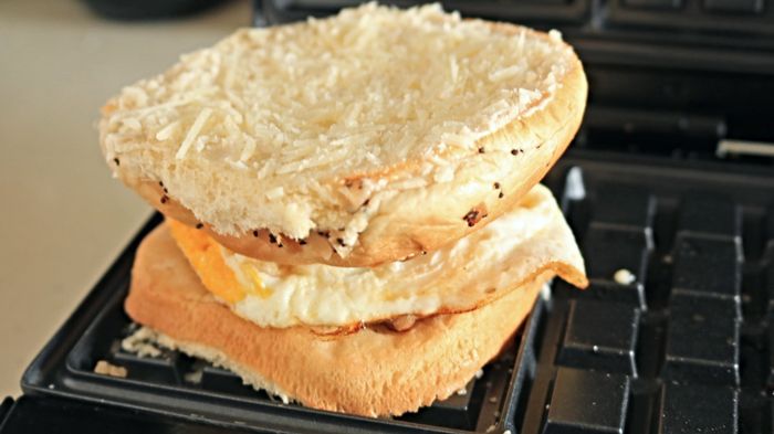 A tasty egg sandwich cooked in a waffle iron.