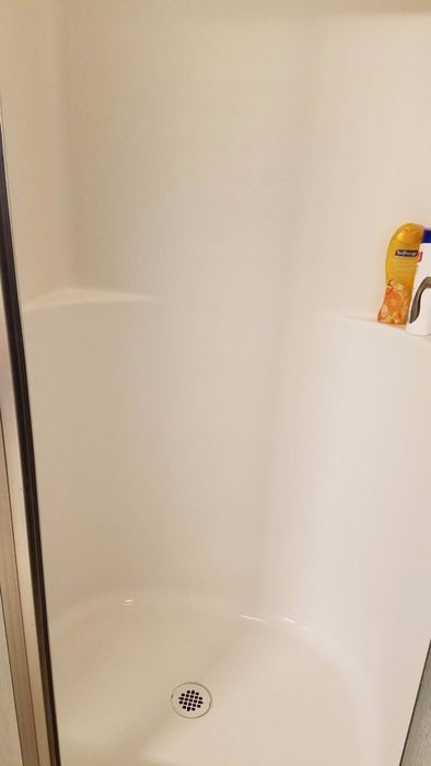 The same shower now spotless and white, free of any rust stains.