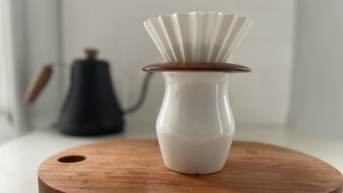 A coffee maker elegantly positioned atop a sleek, curved carafe