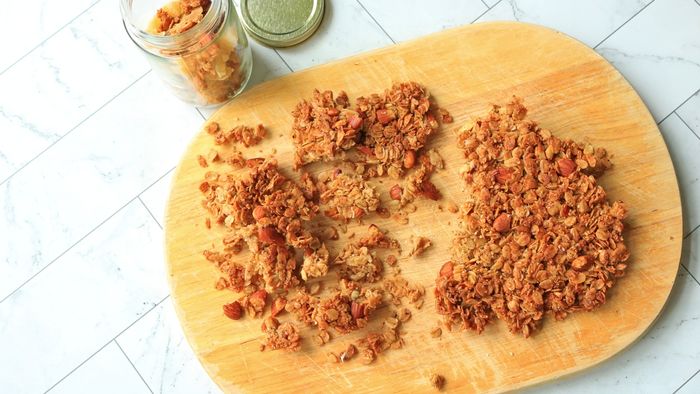 Granola clusters neatly arranged on a wooden cutting board.