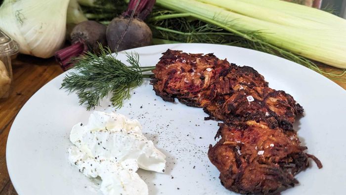 A plate of red flannel latkes accompanied by sour cream.