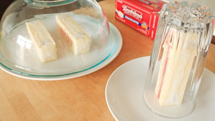 Place two sticks of butter under a glass bowl, or one stick of butter beneath a glass cup.
