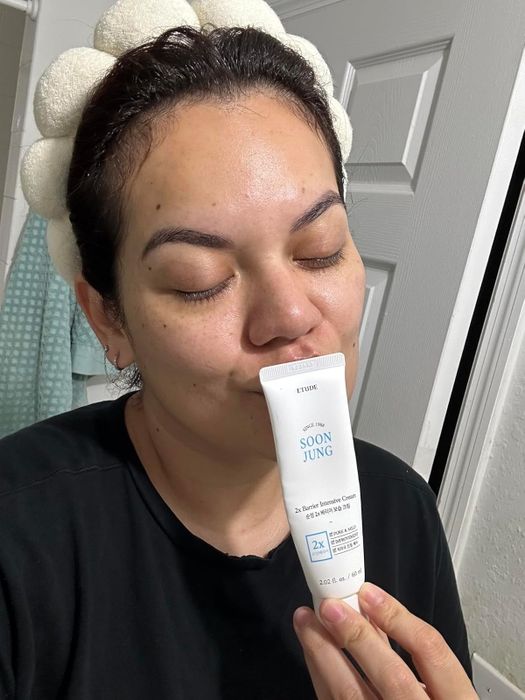 A reviewer giving the bottle of moisturizer a kiss, showing their affection for the product.