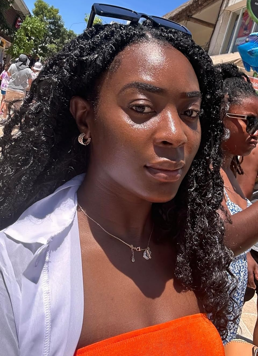 A reviewer outdoors in the sun with glowing skin
