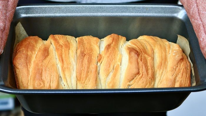 A freshly baked loaf of bread sitting in a pan.