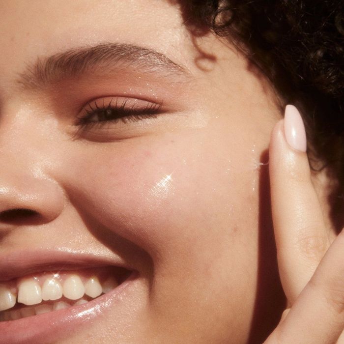 Close-up of a smiling person with glowing skin, showcasing the effects of a beauty or skincare product