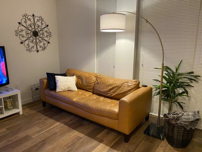 A cozy living room lit by the warm glow of an arc floor lamp
