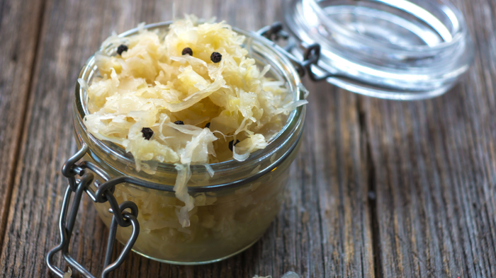 A jar of sauerkraut resting on a wooden surface