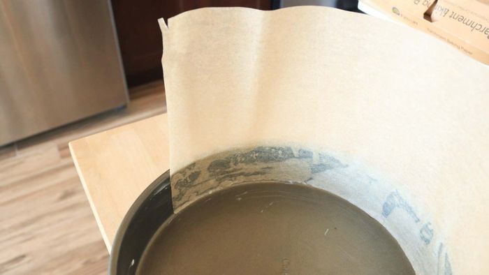 Parchment paper pressed against the wall of a cake pan.