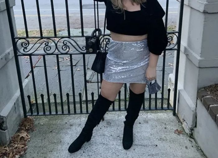 A reviewer styling the boots with a sparkling sequin skirt