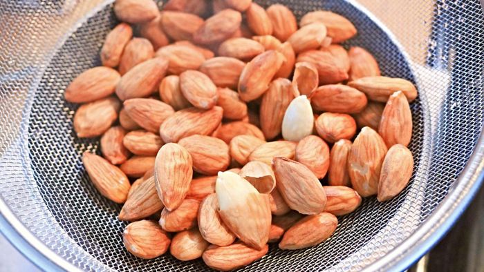 Almonds resting in a sieve.