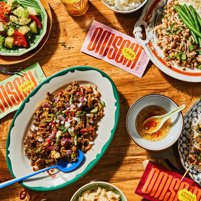 A set of sauce packets displayed on a table alongside dishes made using the flavor starter kit.