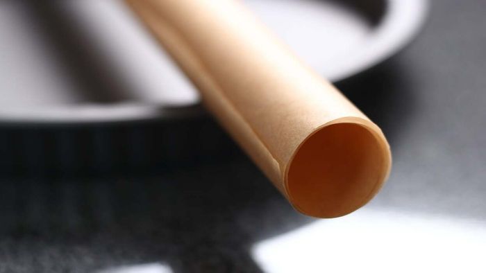 A roll of parchment paper placed on a cake pan.