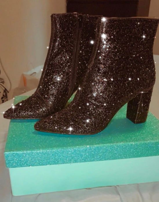 Another reviewer displays a pair of black rhinestone boots, elegantly placed on top of a box for a dramatic effect.