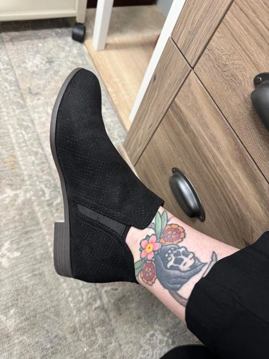 A reviewer wearing black booties.