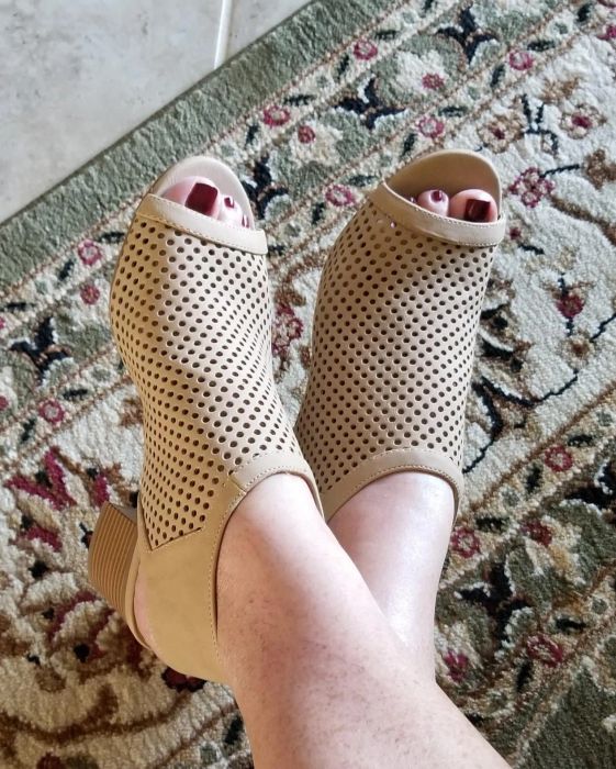 A reviewer sports tan peep-toe booties with a casual yet stylish outfit.