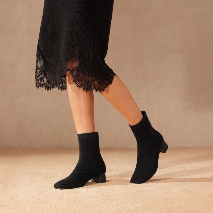 A model wearing the boots in black