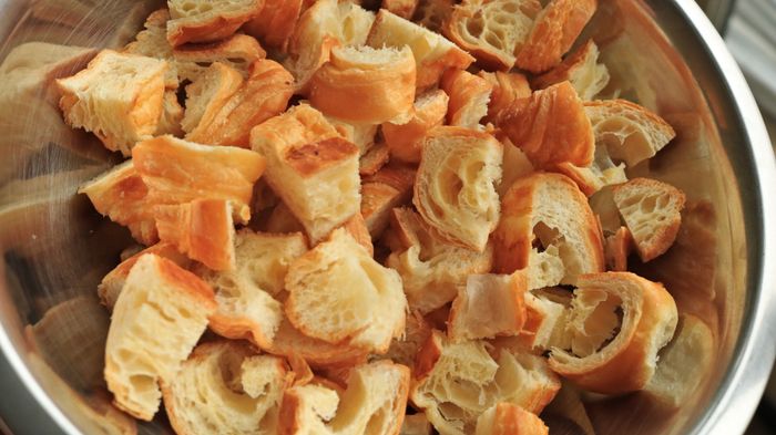 A bowl filled with cubed croissant pieces.