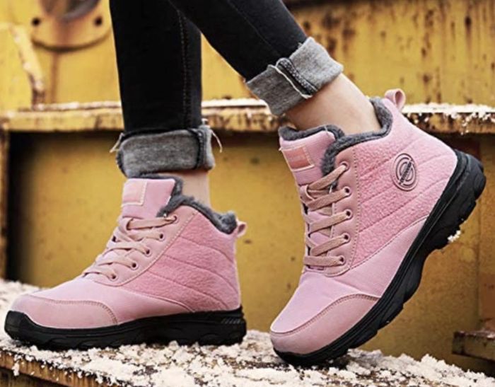 A model stylishly rocking a pair of soft pastel pink lace-up boots.
