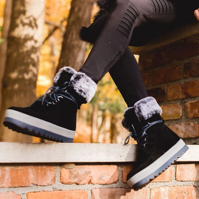 A model wearing the boots in black