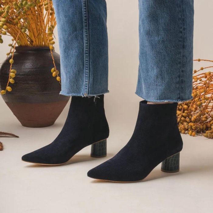 A model showcasing the midnight-colored boots with a round heel.
