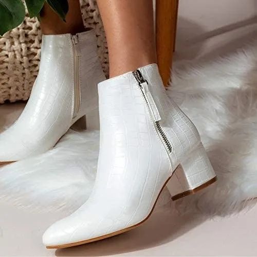 A model shows off a white pair of booties with a croc print design.