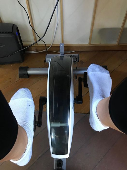 A top-down view of a reviewer using the bike, demonstrating its slim design.