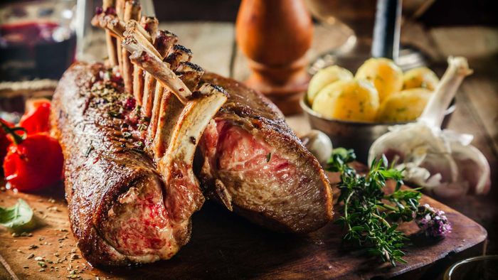A beautifully roasted rack of lamb placed elegantly on a dinner table.