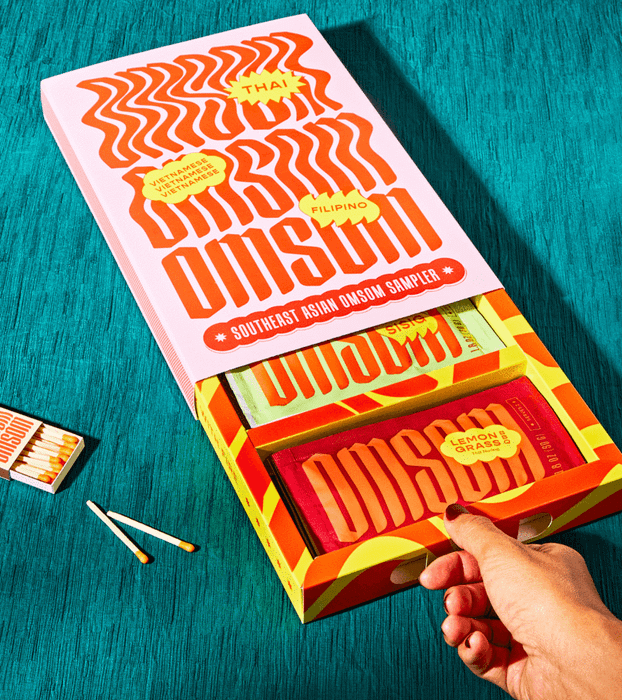 A hand carefully opens the box to reveal the starter packets inside.
