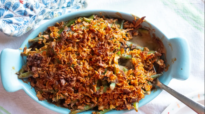 A green bean casserole served with a spoon.