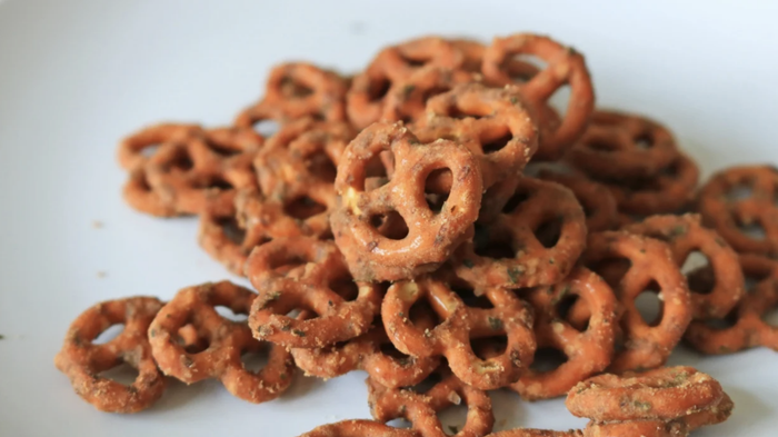 A heap of seasoned pretzels arranged on a white plate.