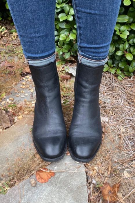 Reviewer rocking black boots paired with blue jeans outdoors