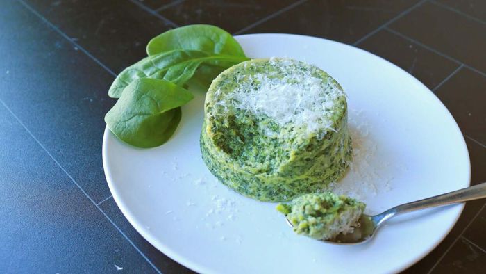 A plate of spinach sformati garnished with parmesan cheese.