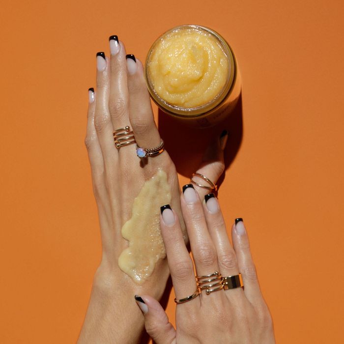 The orange scrub on a hand, showcasing its slightly textured, gritty feel.