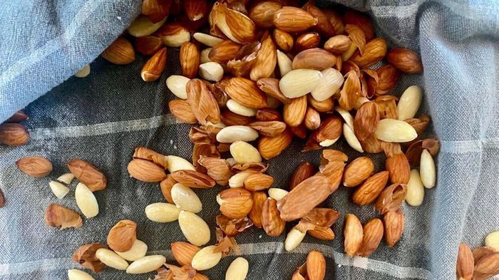 A handful of almonds laid out on a kitchen towel.