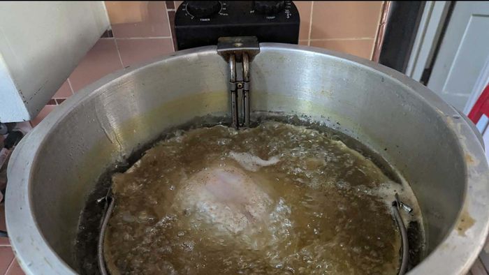 Image of a turkey submerged in hot oil.