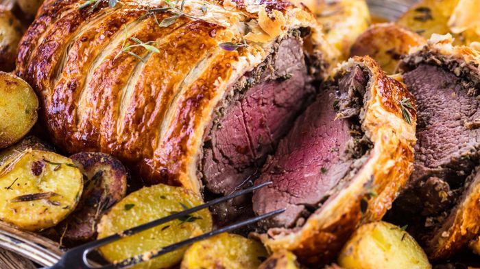 Beef Wellington served and sliced on a platter.