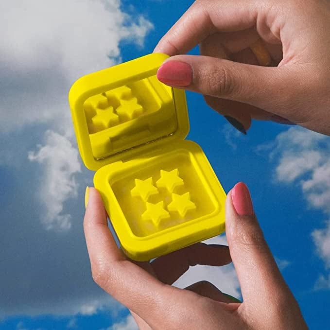 A model holding the yellow compact packaging