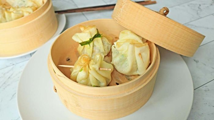 Dumplings placed inside a bamboo steamer basket.