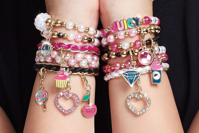 Models showcasing hands adorned with personalized Juicy Couture bracelets.