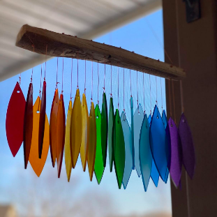 Rainbow-colored glass feathers gracefully suspended from a natural wooden stick.